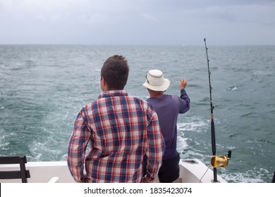 A Man And Fishing Guide Checks His Fishing Rods On A Charter Boat In Varadero, Cuba On A Day Excursion Deep Sea Fishing In The Caribbean Ocean