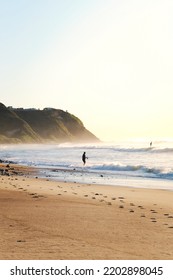 Man Fishing In The Ocean At Burwood Beach, New South Wales, Australia During Sunset