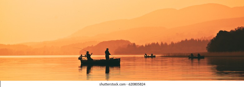 Man fishing on lake from boat at sunset. Lake of Menteith, Stirlingshire, Scotland, UK - Powered by Shutterstock