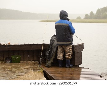 Man Fishing On The Pier, On A Rainy And Foggy Day