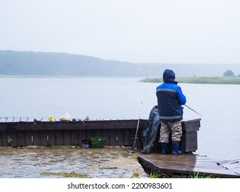 Man Fishing On The Pier, On A Rainy And Foggy Day