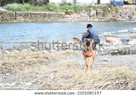 man fishing in the river . with our dog