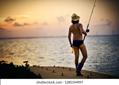 Man fishing wearing Speedos and gumboots