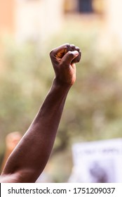 Man Fist With Unfocused Background In A Pacifist Protest Against Racism Demanding Justice