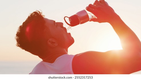 Man, fitness and drinking with water bottle in sunset for hydration, mineral liquid or refreshment. Active, male person or runner with lens flare, aqua beverage or thirst for natural sustainability - Powered by Shutterstock