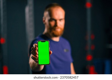 man fitness trainer show phone with green screen sport lifestyle training technology - Powered by Shutterstock