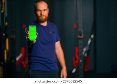 man fitness trainer show phone with green screen sport lifestyle training technology - Powered by Shutterstock