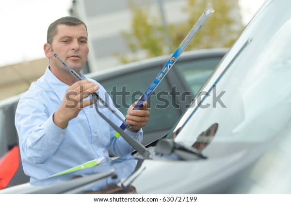 Man fitting new
windcreen wiper blade