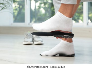 Man Fitting Orthopedic Insole Indoors, Closeup. Foot Care