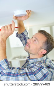 Man Fitting A Smoke Alarm