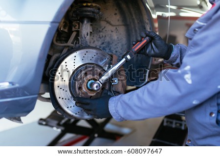 Man fixing brake disk. Selective focus.
