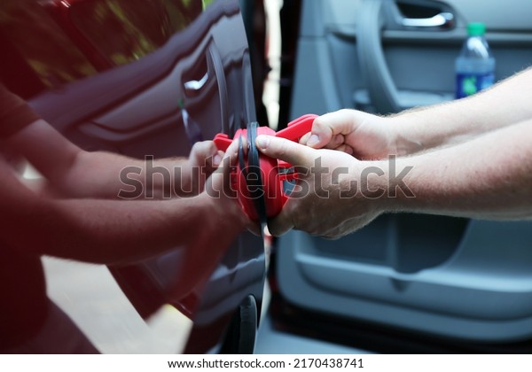 Man fixing car  dent by\
himself