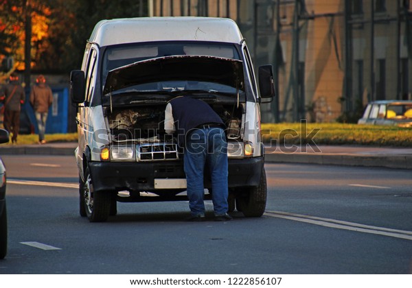 man fixing a car on the
road