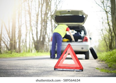 Man Fixing A Car Problem After Vehicle Breakdown On The Road