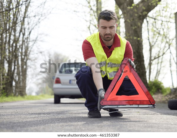 man fixing a car problem after vehicle breakdown on\
the road