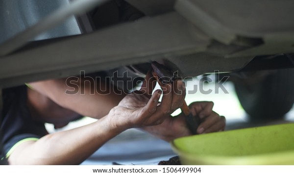 man fixing up a car using\
wrench