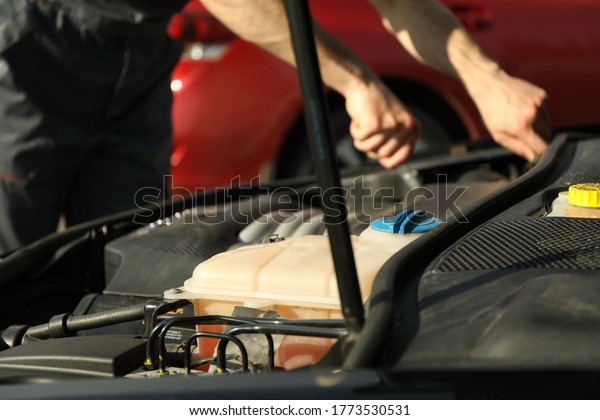 Man\
fixing engine. Car inspection. Work of\
mechanic