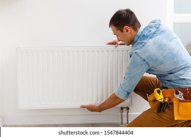 man fixing a heating radiator