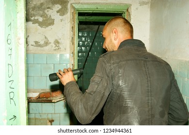 man with a flashlight in an abandoned building