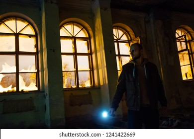 Man with flashlight in dark creepy abandoned mansion at night - Powered by Shutterstock