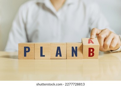 Man flip wooden cube with the word PLAN A to PLAN B on white background. Business concept