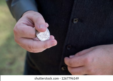 Man Flipping Old Coin In Hand