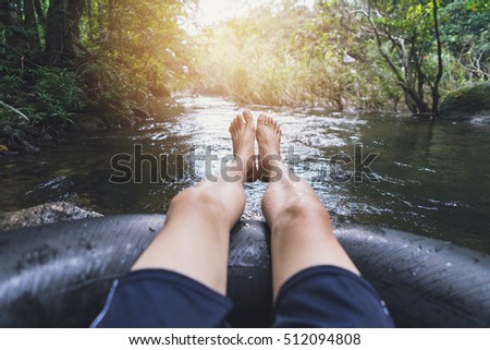 Man floating down a river in a blow up tube