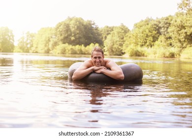 Man Floating In Inner Tube In Lake