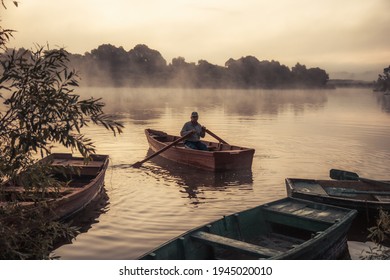 Man floating on river boat with beautiful morning countryside scenery with fog on river with tranquil water during sunrise   - Powered by Shutterstock