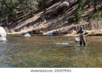 Man fly fishing alone in Cheesman Canyon, Colrado on a sunny day - Powered by Shutterstock