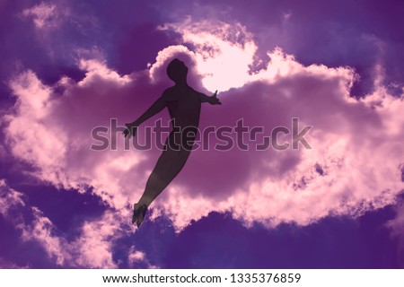 The man is flying in dreams through the cloudy night sky. The opened  arms. Freedom and dreaming concept