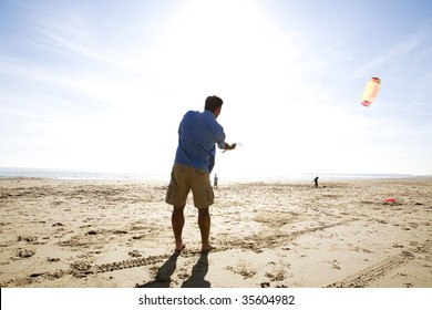 A Man Flying A Kite At The Beach