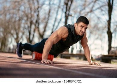 Man Foam Rolling. Athlete Stretches Using Foam Roller.