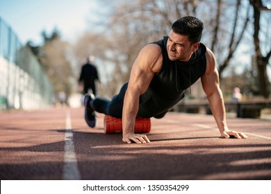 Man foam rolling. Athlete stretches using foam roller. - Shutterstock ID 1350354299