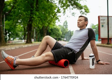 Man Foam Rolling. Athlete Stretches Using Foam Roller.