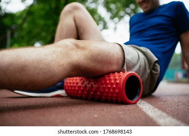 Man Foam Rolling. Athlete Stretches Using Foam Roller.