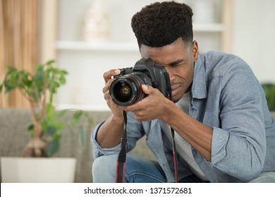 man focusing his camera to photograph a houseplant - Powered by Shutterstock