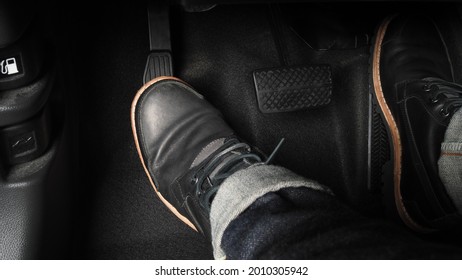 Man foot and accelerator and brake pedal inside the car or vehicle and copy space which black color leather shoe stepped on it for speed up or control automobile pace power. Automobile Driving concept - Shutterstock ID 2010305942