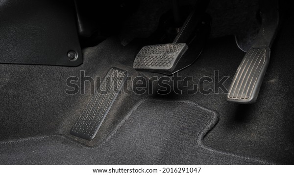 Man foot and accelerator and brake pedal inside\
the car or vehicle and copy space which black color leather shoe\
stepped on it for speed up or control automobile pace power.\
Automobile Driving concept