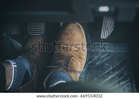 Man foot press the break  pedal of a car.