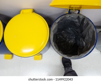 Man Foot Treading Toxic Waste Bin.Row Of Different Bins In The Office. Recycling Bins At The Waste Zone.Recycle Garbage Bin For Safe Environment.Safe The World.