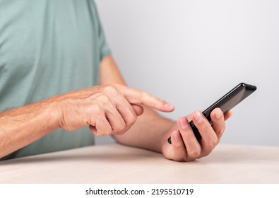 Man Forefinger Clicking Ok Button At Phone. Male Using Smartphone For Sending E-mail, Checking Bank Balance, Making Payments. High Quality Photo