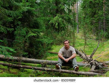 The Man In  Forest Sits On A Log