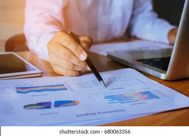 Man in a formal business suit pointing at business chart
