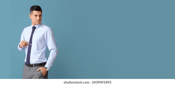 Man in formal clothes and with necktie clip on blue background with space for text