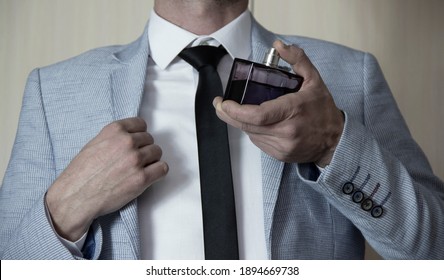 Man In Formal Suit, Bottle Of Perfume, Closeup. Fragrance Smell. Men Perfumes. Fashion Cologne Bottle.

