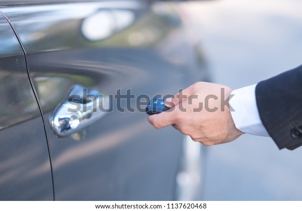 Man\
in formalwear open car door, Hand on car door\
handle