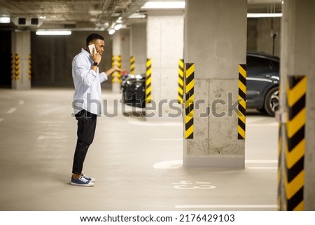 The man found his car missing. Angry African American talking about a missing car on the phone. Car theft concept