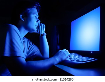 Man In Front Of Computer Screen. Dark Night Room And Blue Light.