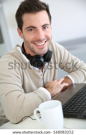 Man in front of laptop computer with headset